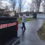 Worker seal coating a driveway