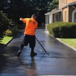 Worker sealcoating by hand