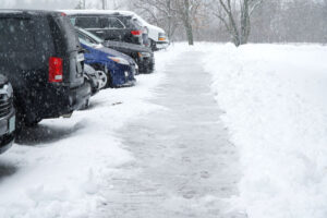 Line of cars parked in snow covered parking lot